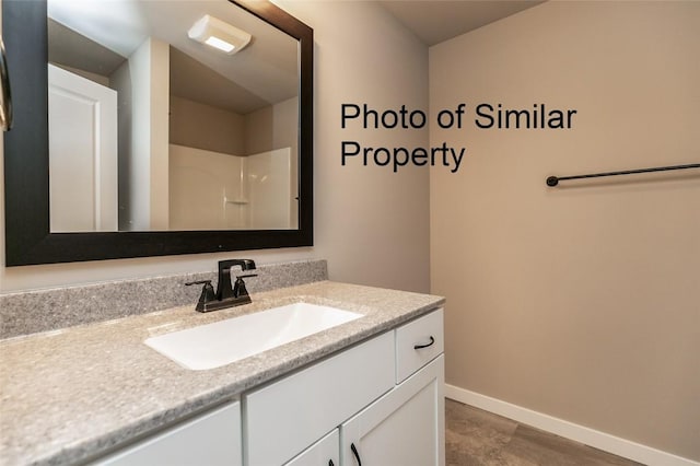 bathroom featuring a shower and vanity