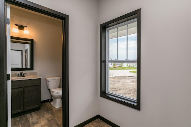 bathroom featuring hardwood / wood-style floors, vanity, toilet, and a healthy amount of sunlight