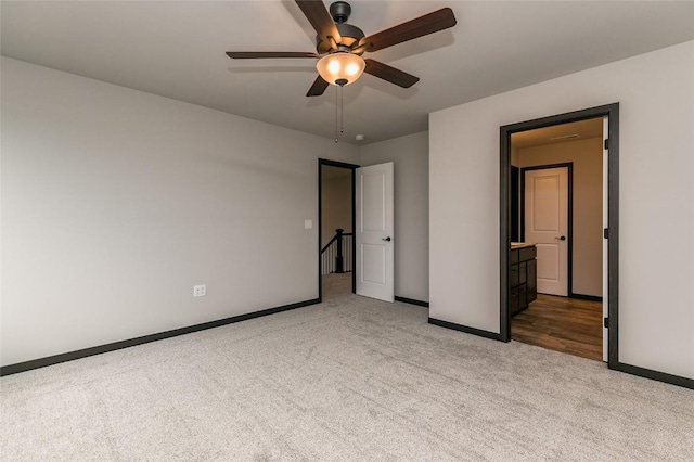 unfurnished bedroom featuring light carpet, connected bathroom, and ceiling fan