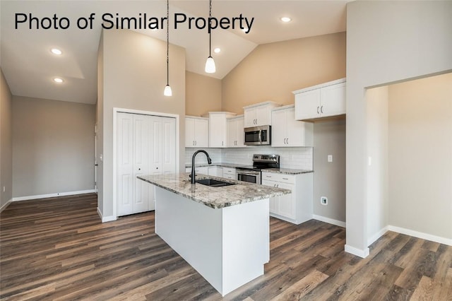 kitchen with sink, stainless steel appliances, light stone counters, a center island with sink, and white cabinets