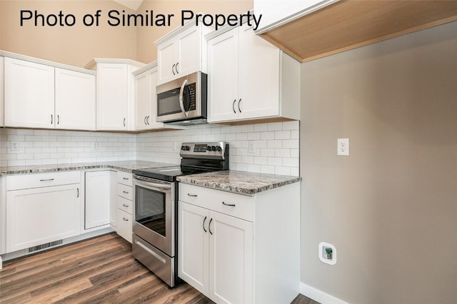 kitchen featuring white cabinets, appliances with stainless steel finishes, tasteful backsplash, and light stone countertops