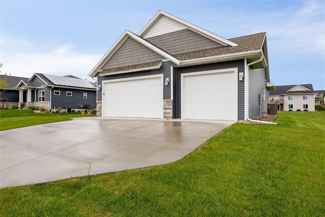 view of front of home with central AC, a front lawn, and a garage