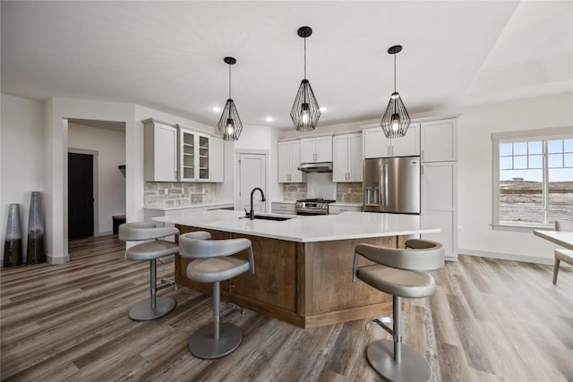kitchen with light countertops, appliances with stainless steel finishes, a sink, and wood finished floors