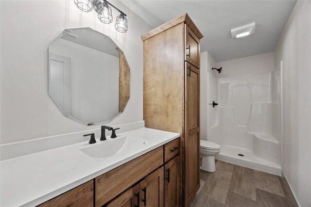 bathroom with toilet, walk in shower, and vanity