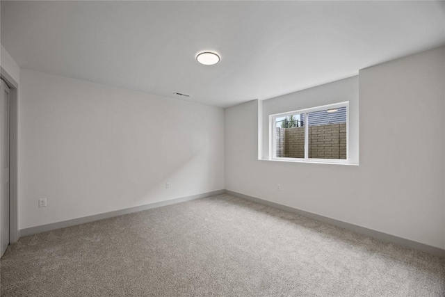 empty room featuring baseboards, visible vents, and light colored carpet