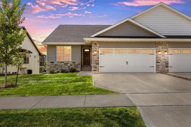 craftsman inspired home with a yard, a garage, and central air condition unit