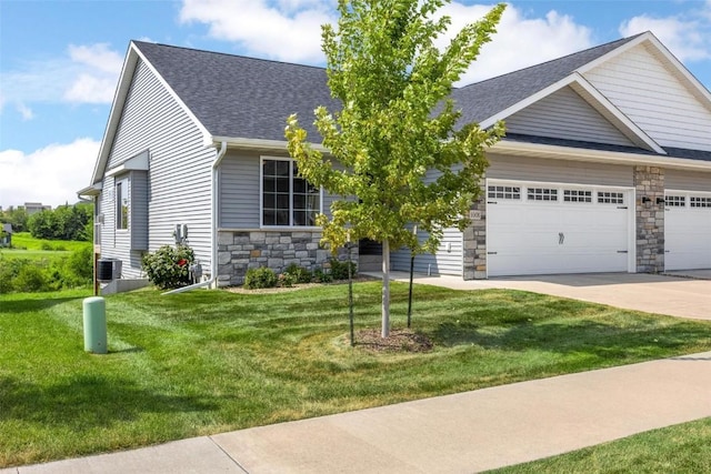 view of front of home featuring a front yard, a garage, and cooling unit