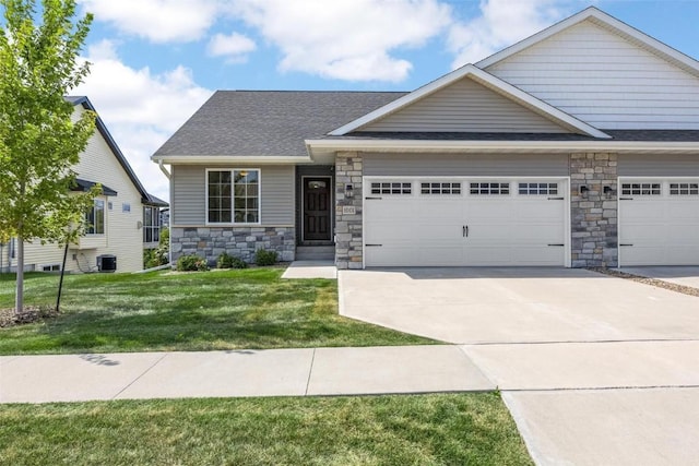 craftsman inspired home featuring a front yard, a garage, and central air condition unit