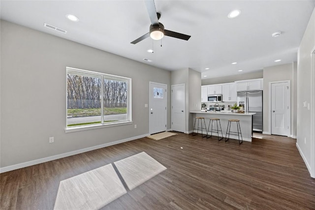 unfurnished living room featuring dark hardwood / wood-style floors and ceiling fan