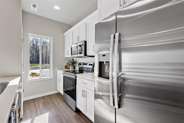 kitchen with white cabinets, appliances with stainless steel finishes, and plenty of natural light