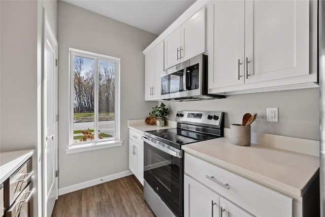 kitchen with white cabinets, appliances with stainless steel finishes, dark hardwood / wood-style flooring, and plenty of natural light