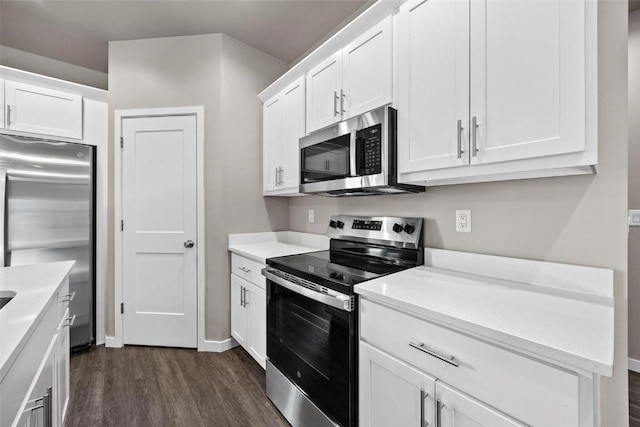 kitchen featuring stainless steel appliances, white cabinetry, and dark hardwood / wood-style floors