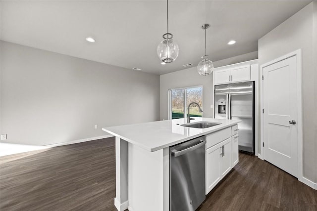 kitchen with white cabinets, stainless steel appliances, a center island with sink, and sink