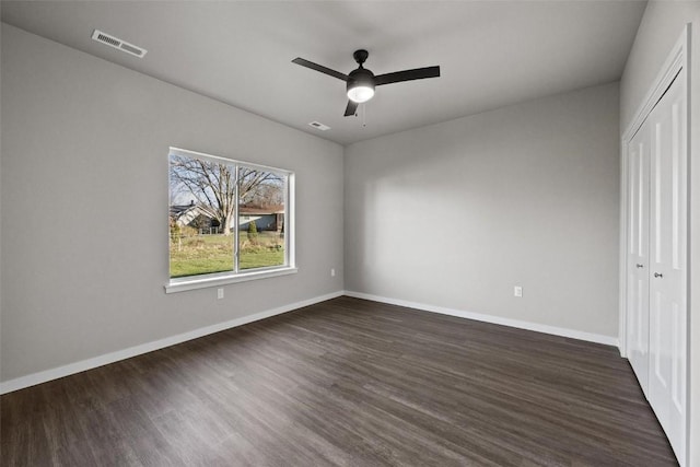 unfurnished bedroom with ceiling fan, dark hardwood / wood-style flooring, and a closet