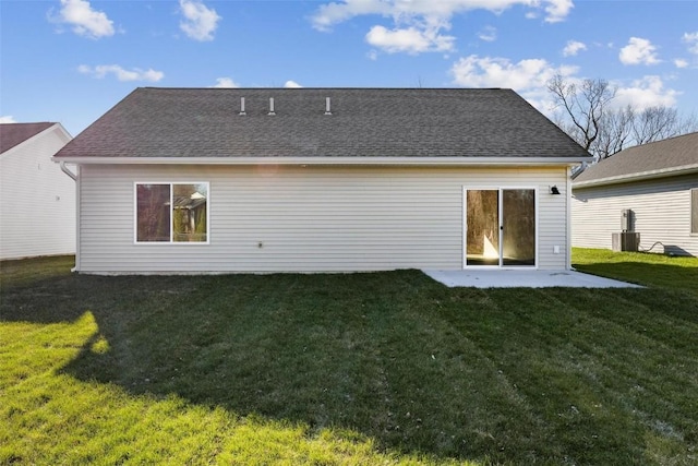 back of property with central air condition unit and a lawn