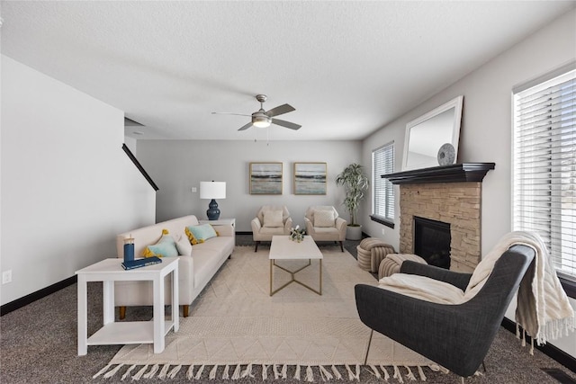 living room featuring ceiling fan, a fireplace, light carpet, and a textured ceiling