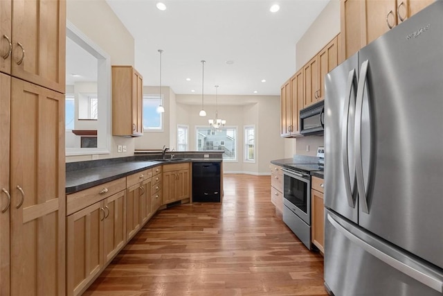 kitchen featuring an inviting chandelier, black appliances, sink, hanging light fixtures, and kitchen peninsula