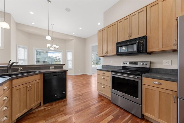 kitchen with an inviting chandelier, black appliances, sink, hanging light fixtures, and wood-type flooring