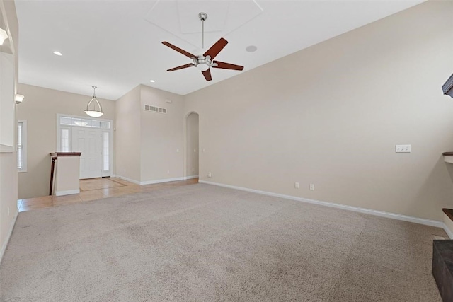 unfurnished living room with light colored carpet and ceiling fan