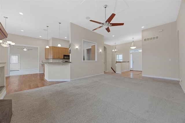 unfurnished living room featuring ceiling fan and light colored carpet