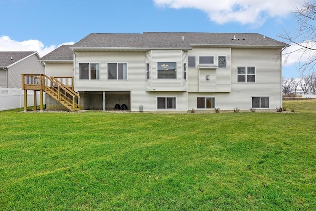 back of house featuring a lawn and a wooden deck