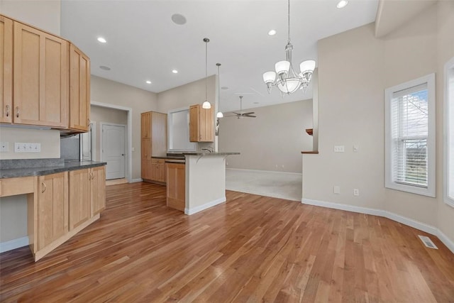 kitchen with a breakfast bar, hanging light fixtures, and light brown cabinetry