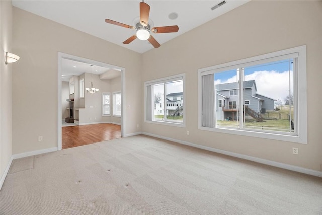 unfurnished living room with carpet flooring and ceiling fan with notable chandelier