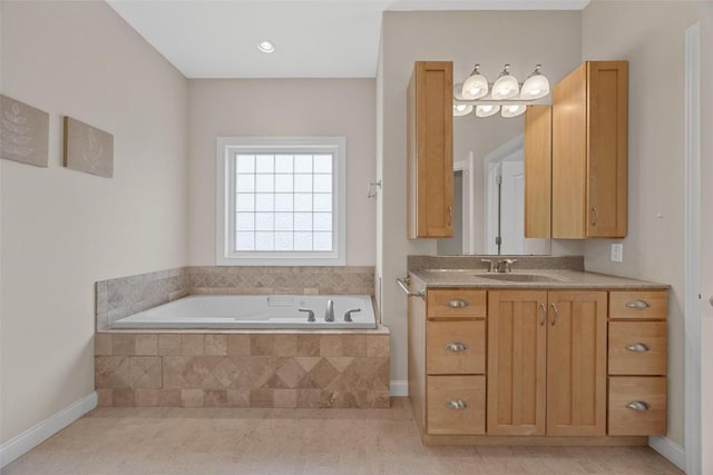 bathroom featuring tile patterned flooring, vanity, and tiled tub