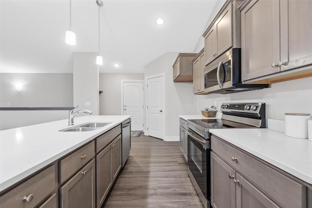 kitchen with dark hardwood / wood-style floors, sink, stainless steel appliances, and decorative light fixtures