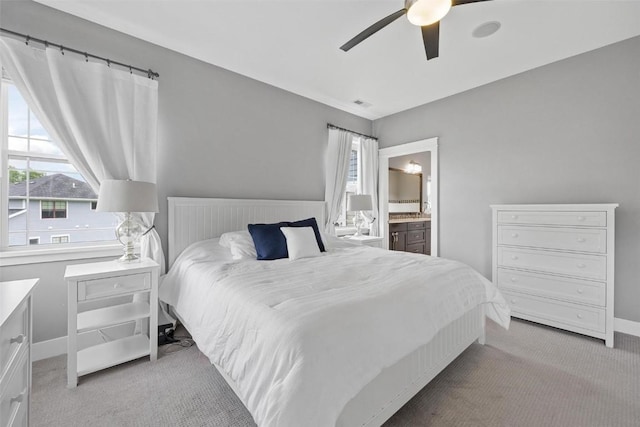 bedroom featuring connected bathroom, ceiling fan, and light carpet