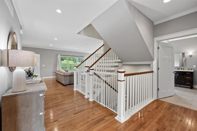 stairway featuring hardwood / wood-style floors and crown molding