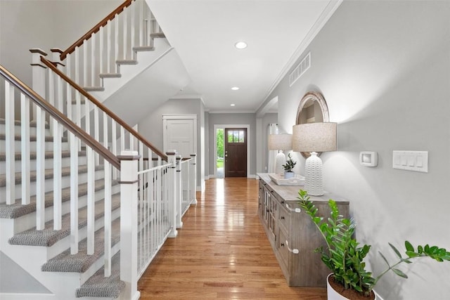 entryway featuring crown molding and light hardwood / wood-style flooring