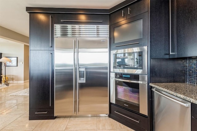 kitchen featuring stone counters, light tile patterned floors, and appliances with stainless steel finishes