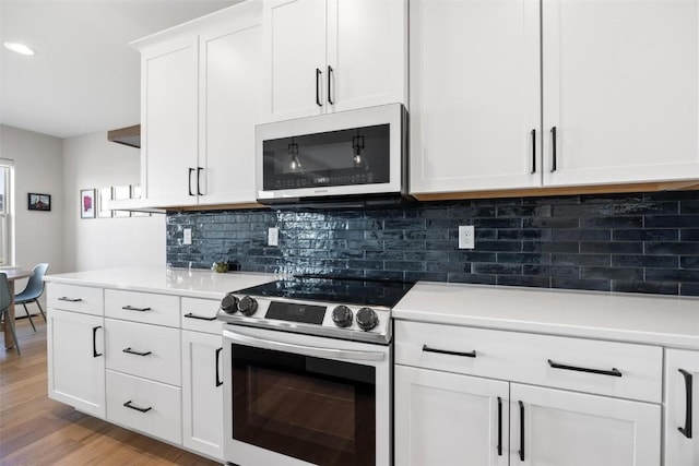 kitchen with white cabinetry, decorative backsplash, stainless steel electric range oven, and light hardwood / wood-style flooring