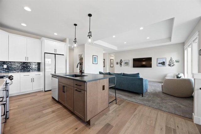 kitchen with sink, white cabinetry, an island with sink, and appliances with stainless steel finishes