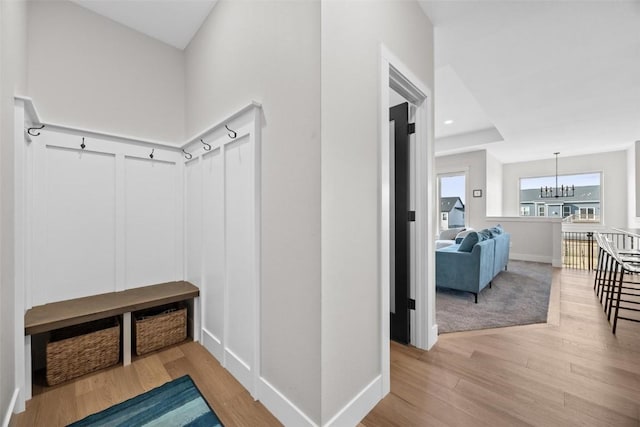 mudroom with a chandelier and light hardwood / wood-style floors