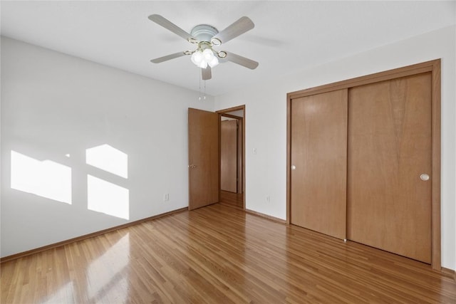 unfurnished bedroom featuring ceiling fan, a closet, and hardwood / wood-style flooring