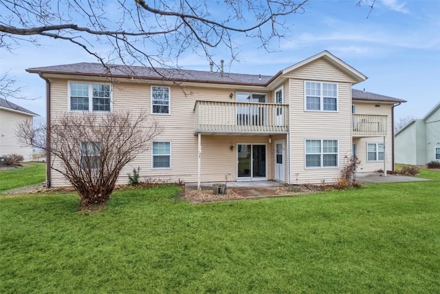 rear view of house with a patio area, a balcony, and a yard