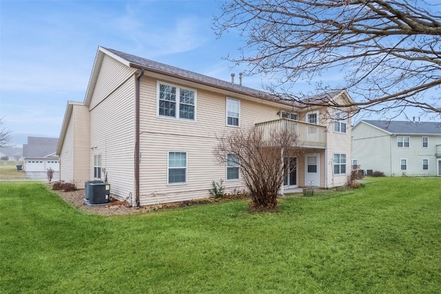 back of property featuring central air condition unit and a yard