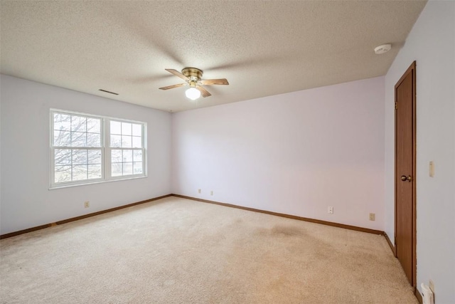 carpeted empty room featuring ceiling fan and a textured ceiling