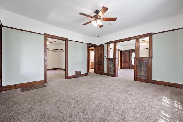 unfurnished bedroom featuring ceiling fan, carpet floors, and ensuite bath