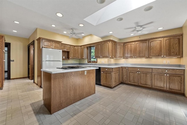 kitchen featuring stainless steel gas stovetop, a center island, white refrigerator, a skylight, and black dishwasher