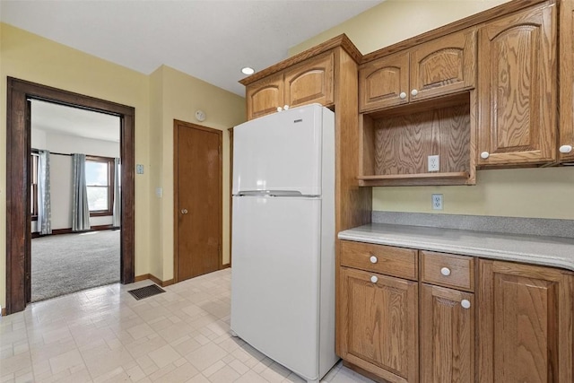 kitchen featuring white refrigerator and light carpet