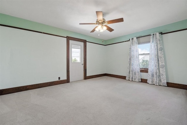 spare room featuring ceiling fan, a healthy amount of sunlight, and light carpet