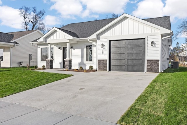 view of front facade with a front yard, a garage, and cooling unit