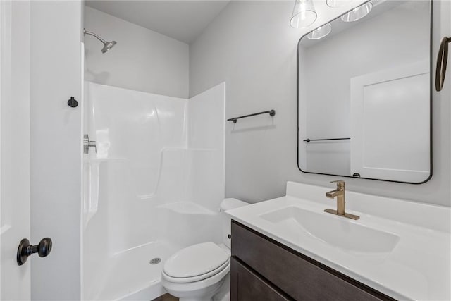 bathroom featuring vanity, toilet, and walk in shower