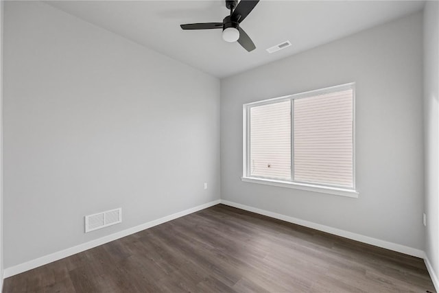 spare room with ceiling fan and dark wood-type flooring