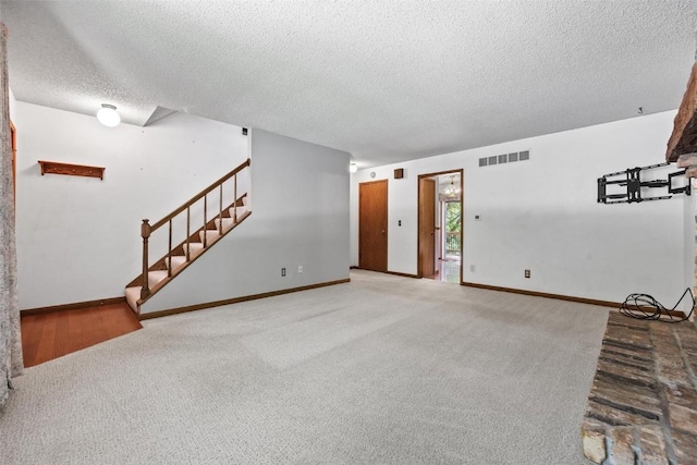 unfurnished living room featuring carpet and a textured ceiling