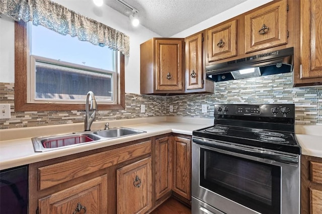 kitchen featuring a textured ceiling, backsplash, stainless steel electric stove, and sink