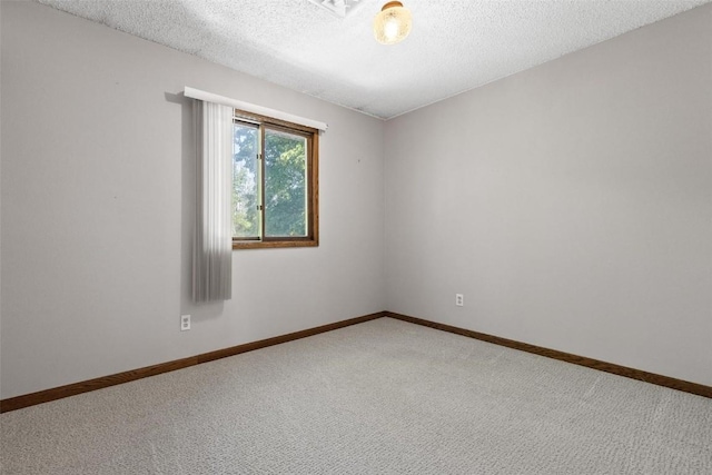 carpeted spare room with a textured ceiling